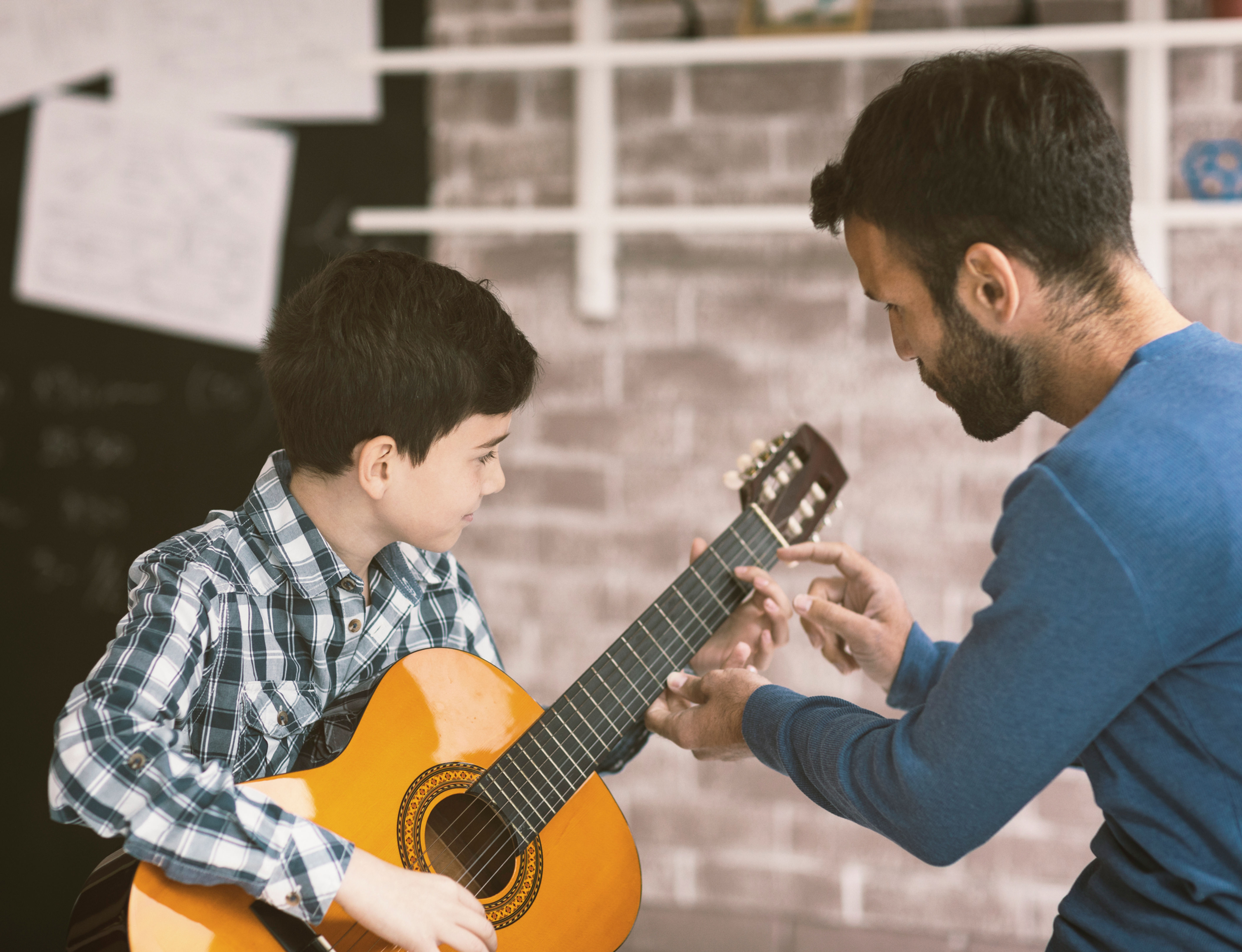 Instructor teaching acoustic guitar finger placement