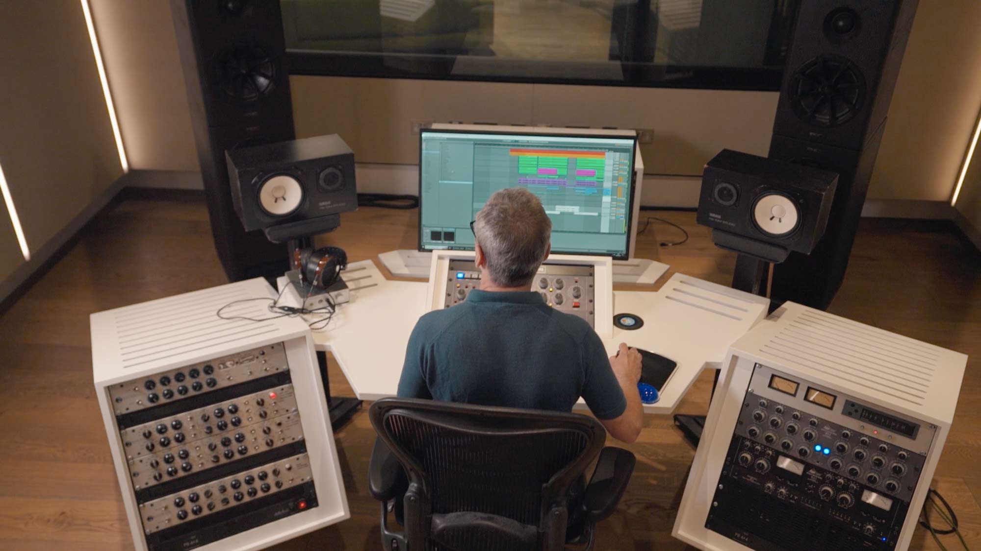 Professional engineer teaching mixing and mastering at a studio console