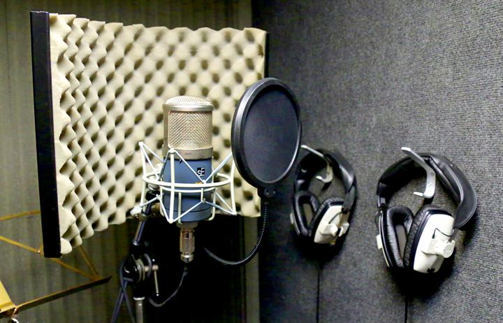 Professional microphone and headphones in a vocal recording booth