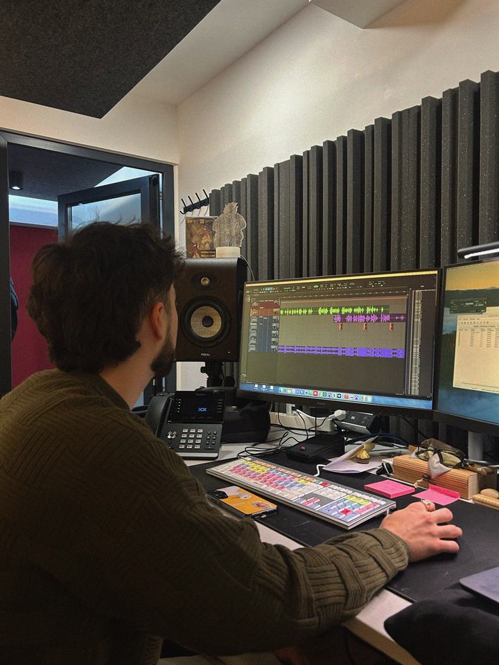 Sound designer editing audio on a dual-screen workstation